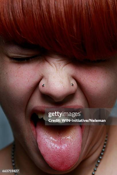 close-up of a female teenager sticking her tongue out - nose piercing stock pictures, royalty-free photos & images