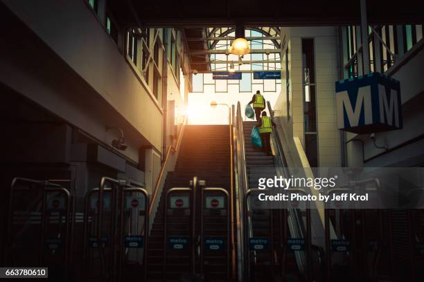 cleaning workers walking up the stairs in a metro/subway underground station. sunlight at the end, in a cinematic scene. - dageraad fotografías e imágenes de stock