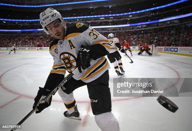 Patrice Bergeron of the Boston Bruins bounces the puck off of the glass against the Chicago Blackhawks at the United Center on April 2, 2017 in...