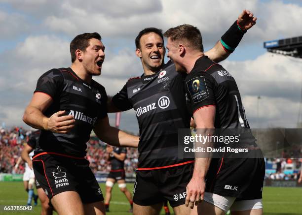 Chris Ashton of Saracens is congratulated by team mates Alex Goode and Neil de Kock after scoring his second try during the European Rugby Champions...