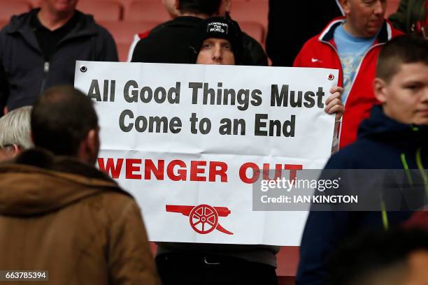 Supporter holds up an anti-Wenger placard in the crowd after the English Premier League football match between Arsenal and Manchester City at The...