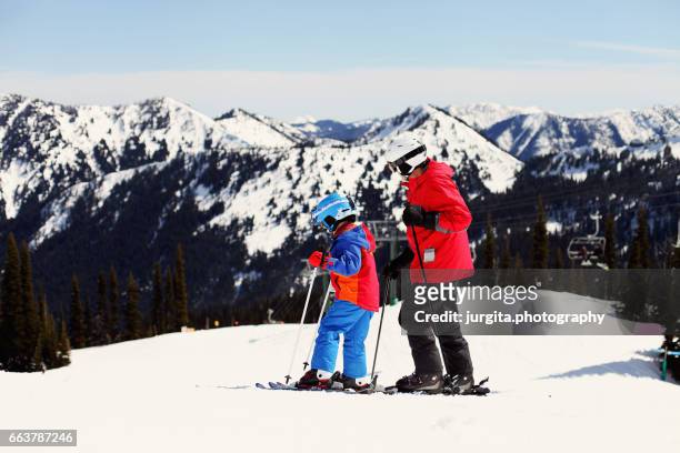 winter breaks. father and young child skiing - crystal - fotografias e filmes do acervo