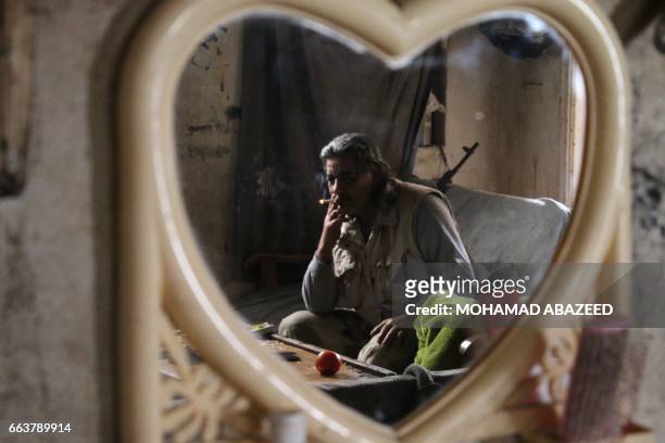 Abu Haitham, a 57-year-old rebel fighter from the Free Syrian Army's 18 March Division, sits in a building on the front line in the southern city of...