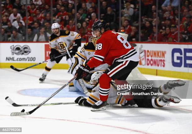 Patrick Kane of the Chicago Blackhawks tries to get off a shot as Torey Krug of the Boston Bruins drops to block in the second period at the United...
