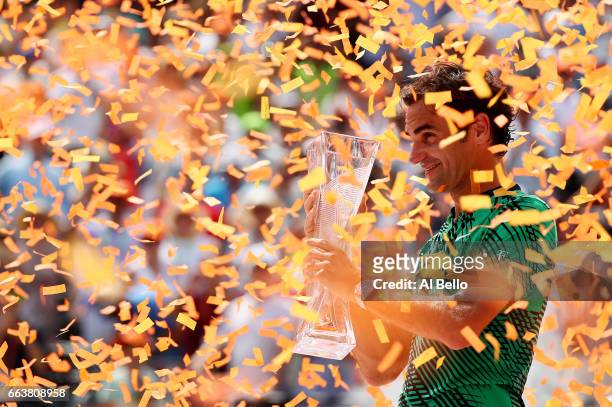 Roger Federer of Switzerland holds the winner's trophy after defeating Rafael Nadal of Spain during the Men's Final and day 14 of the Miami Open at...