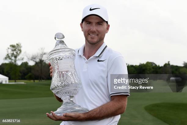 Russell Henley poses with the trophy on the 18th green after winning the Shell Houston Open at the Golf Club of Houston on April 2, 2017 in Humble,...