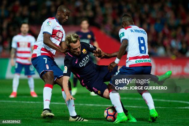 Barcelona's Croatian midfielder Ivan Rakitic vies with Granada's Colombian forward Adrian Ramos and Ghanaian midfielder Wakaso Mubarak during the...