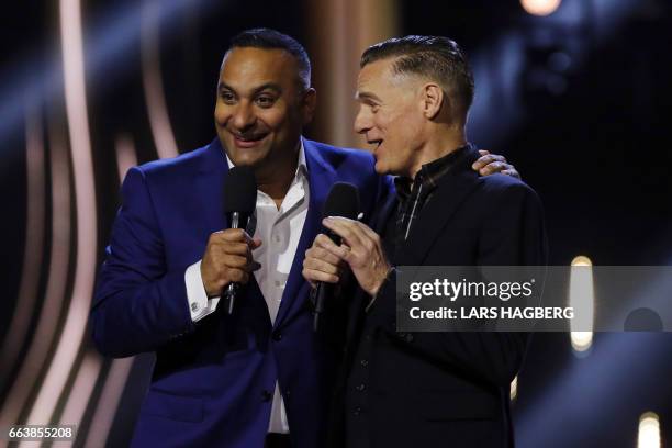 Hosts Russell Peters jokes on stage with Bryan Adams during the JUNO Awards at the Canadian Tire Centre in Ottawa, Ontario, on April 2, 2017. / AFP...
