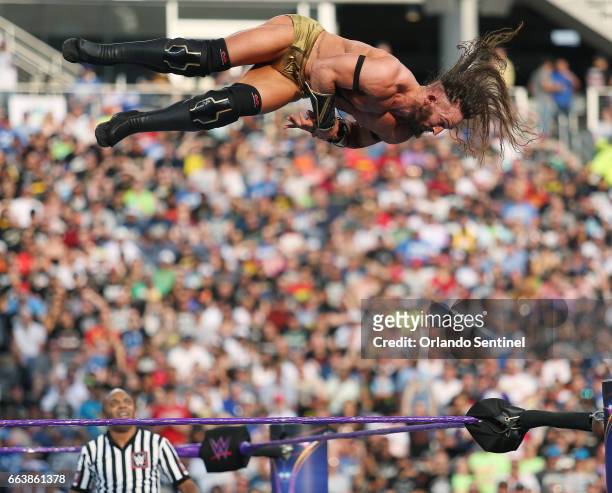 Adrian Neville leaps over the ring during WrestleMania 33 on Sunday, April 2, 2017 at Camping World Stadium in Orlando, Fla.