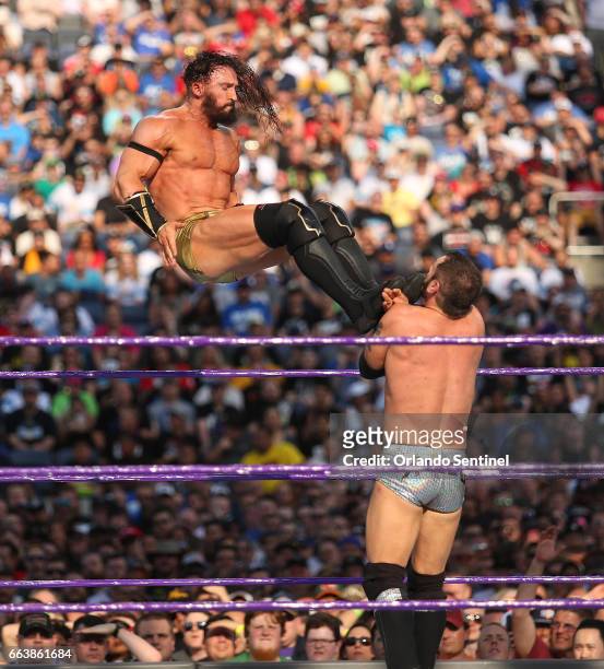 Adrian Neville, top, kicks Austin Aries during WrestleMania 33 on Sunday, April 2, 2017 at Camping World Stadium in Orlando, Fla.