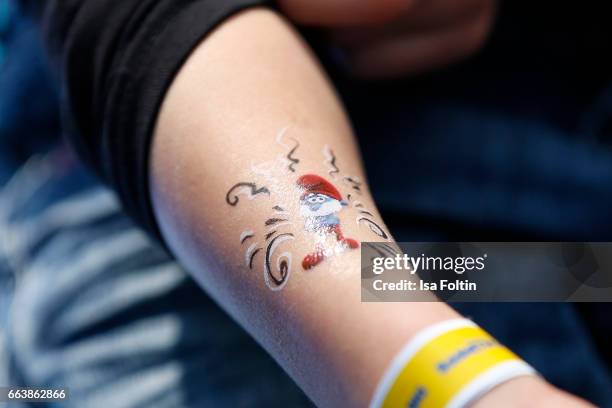 Smurf paintin on a kids arm during the 'Die Schluempfe - Das verlorene Dorf' premiere at Sony Centre on April 2, 2017 in Berlin, Germany.