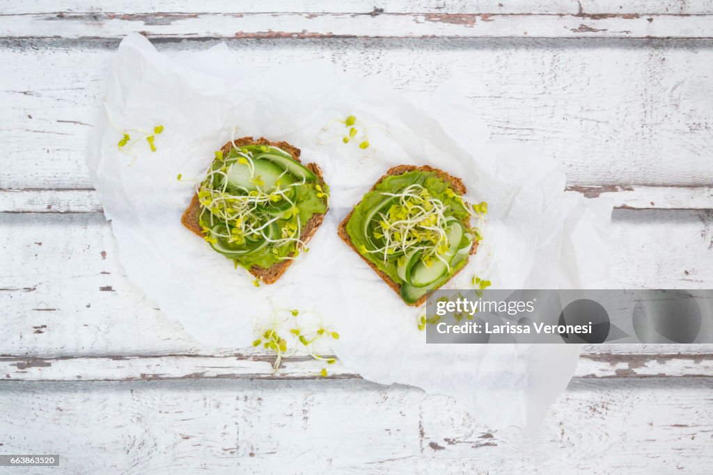 Healthy whole grain bread with avocado, cucumber and sprouts