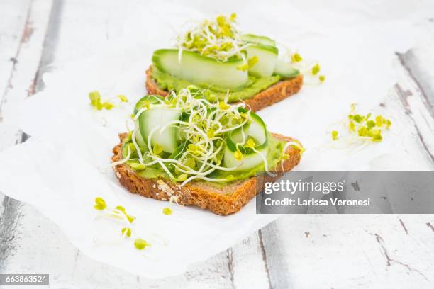 healthy whole grain bread with avocado, cucumber and sprouts - alfalfa stock pictures, royalty-free photos & images