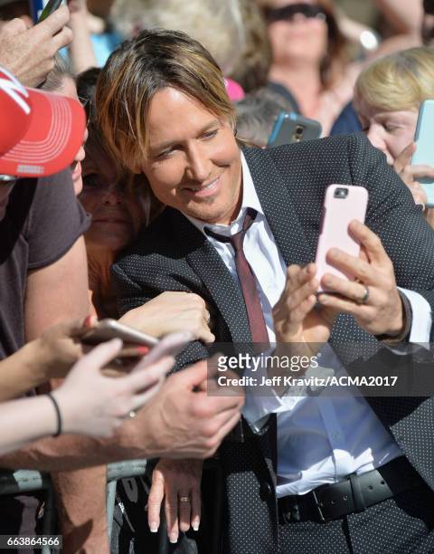 Singer Keith Urban poses for a selfie with a fan before the 52nd Academy Of Country Music Awards at Toshiba Plaza on April 2, 2017 in Las Vegas,...