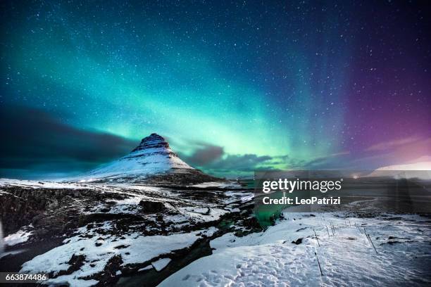 nordlicht in berg kirkjufell island mit einem mann vorbei - iceland landscape stock-fotos und bilder