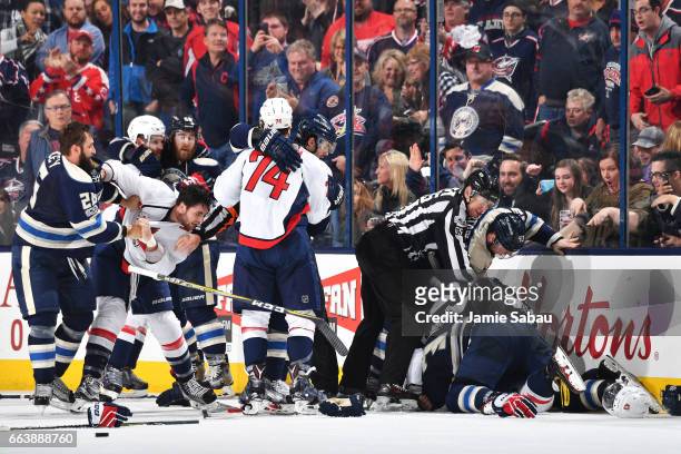 Linesmen Pierre Racicot and Jonny Murray break up a fight during the third period of a game between the Washington Capitals and the Columbus Blue...