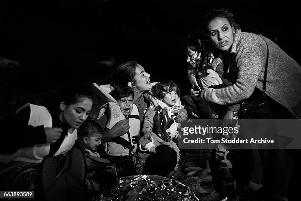 Distraught children are comforted by volunteers on the shoreline of the Greek Island of Lesbos after a hazardous night crossing over the Aegean Sea...