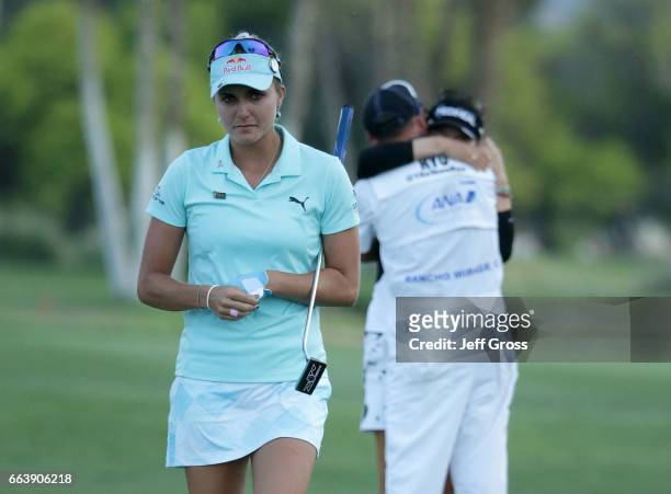 Lexi Thompson walks off the 18th green, as So Yeon Ryu of the Republic of Korea celebrates with her caddie after Ryu defeated Thompson in a playoff...