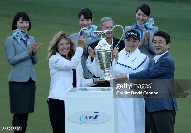 So Yeon Ryu of South Korea is presented with the trophy by Shinya Katanozaka the CEO of ANA and Melissa Montgomery Dinah Shore's daughter after her...