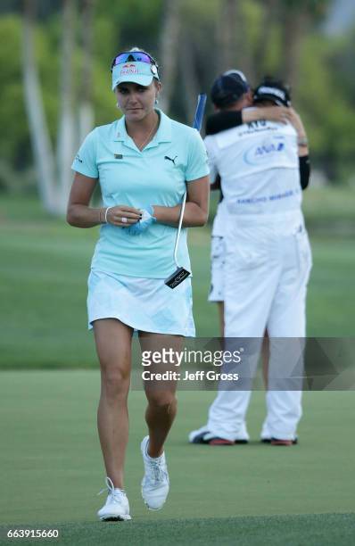 Lexi Thompson walks off the 18th green, as So Yeon Ryu of the Republic of Korea celebrates with her caddie after Ryu defeated Thompson in a playoff...
