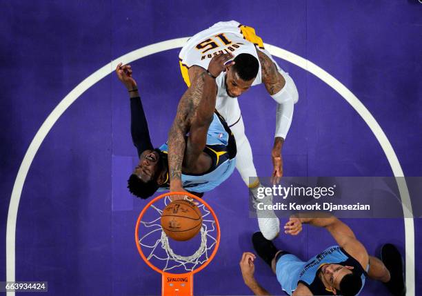 Thomas Robinson of the Los Angeles Lakers dunks over James Ennis III of the Memphis Grizzlies look to pull down a rebound during the first half of...