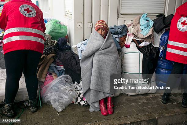 In freezing cold a refugee child waits to cross at the Timovec border crossing between Croatia and Slovenia. The ICRC handed out clothes to try to...