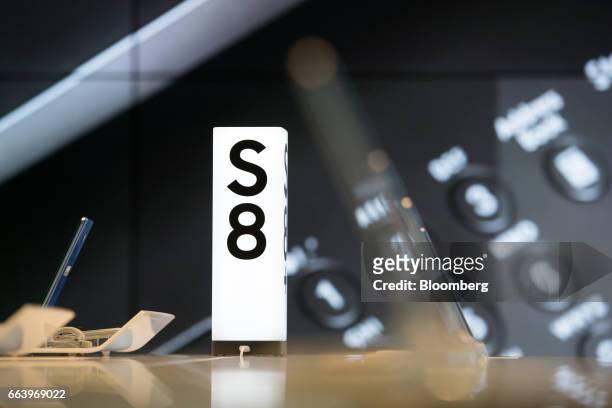 An illuminated signage for Samsung Electronics Co. Galaxy S8 smartphone stands on display at the company's D'light flagship store in Seoul, South...