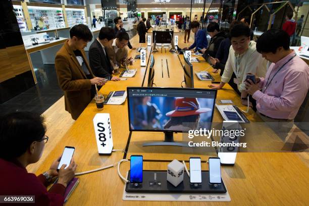 Customers try out Samsung Electronics Co. Galaxy S8 smartphones at the company's D'light flagship store in Seoul, South Korea, on Monday, April 3,...