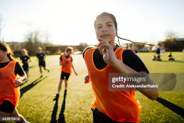 女子サッカー選手と彼女のチーム - 女の子走る ストックフォトと画像