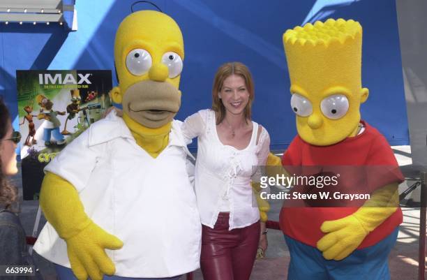 Actress Jenna Elfman poses with Homer and Bart Simpson October 1, 2000 at the premiere of Cyberworld 3D at the Universal Studios IMAX Theatre in...
