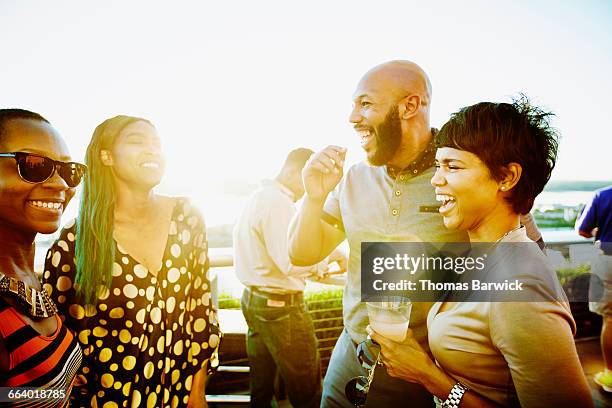 laughing couple sharing drinks with friends - éclat rire femme photos et images de collection