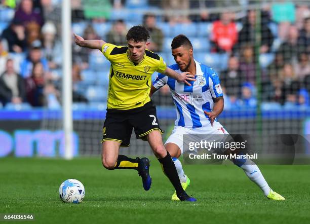 Tom Flanagan of Burton Albion holds off Elias Kachunga of Huddersfield Town during the Sky Bet Championship match between Huddersfield Town and...