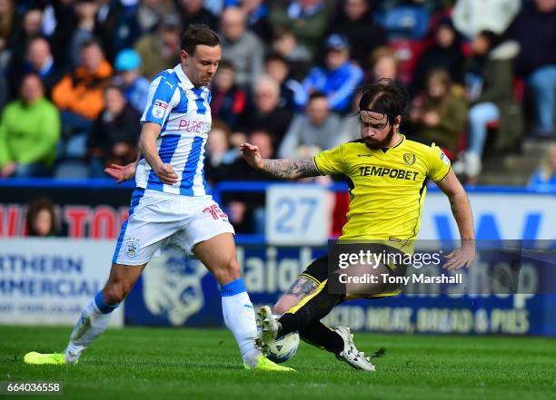 Chris Lowe of Huddersfield Town is tackled by John Brayford of Burton Albion during the Sky Bet Championship match between Huddersfield Town and...