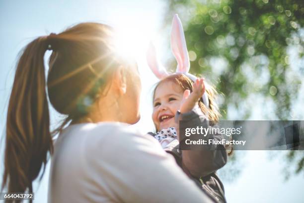 moeder bedrijf kind met bunny oren - pasen stockfoto's en -beelden