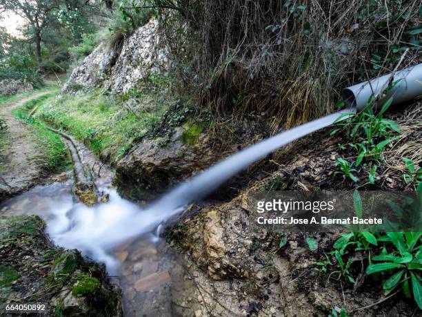 break of a pipeline or water pipe in a natural space, with a direct spillage to the river - conservación del ambiente stock pictures, royalty-free photos & images