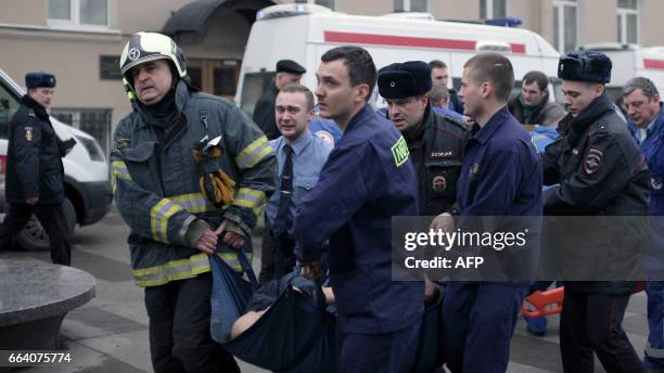 Police and emergency services personnel carry an injured person on a stretcher outside Technological Institute metro station in Saint Petersburg on...