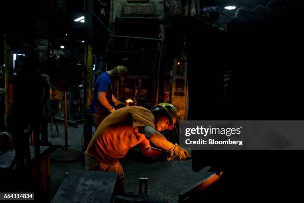 An employee pulls a steel billet from a furnace as tools are forged at the Vaughan & Bushnell Manufacturing Co. Facility in Bushnell, Illinois, U.S.,...