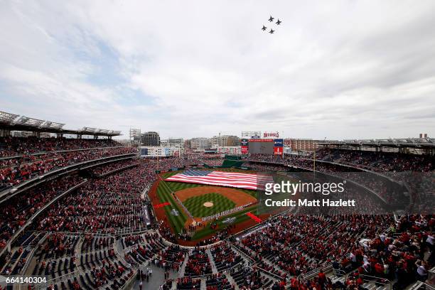 Jets fly over the stadium as the Miami Marlins and Washington Nationals line the field during the national anthem prior to the opening day game at...