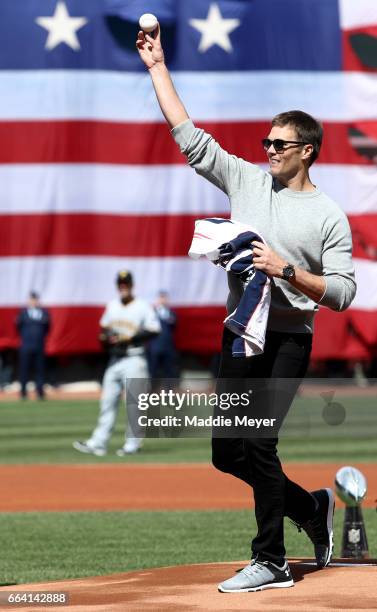 Tom Brady of the New England Patriots throws out the first pitch before the opening day game between the Boston Red Sox and the Pittsburgh Pirates at...