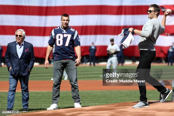 Tom Brady of the New England Patriots throws out the first pitch as Patriots owner Robert Kraft and Rob Gronkowski look on before the opening day...
