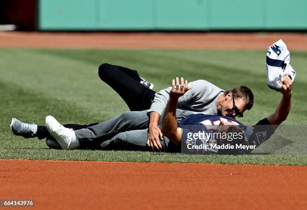 Rob Gronkowski of the New England Patriots is tackled by Tom Brady after stealing his jersey before the opening day game between the Boston Red Sox...