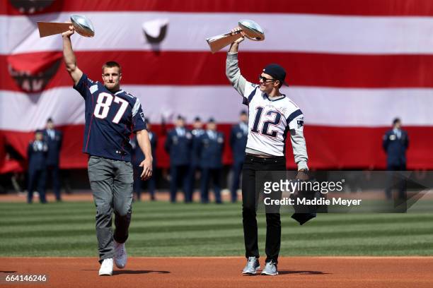 Rob Gronkowski and Tom Brady of the New England Patriots enter the field carrying Vince Lombardi trophies before the opening day game between the...