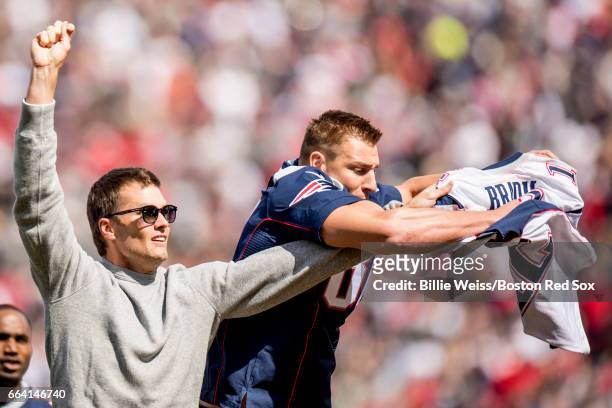 New England Partriots quarterback Tom Brady has his jersey stolen by tight end Rob Gronkowski during a pre-game ceremony before the Boston Red Sox...