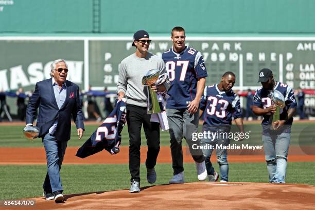 From left, New England Patriots owner Robert Kraft, Tom Brady, Rob Gronkowski, Dion Lewis, and James White walk onto the field carrying Vince...