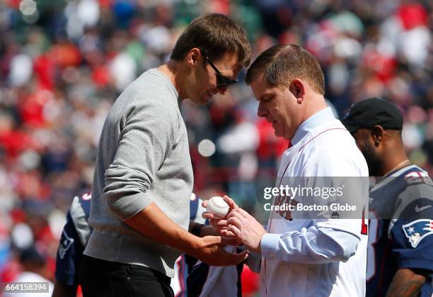 New England Patriots quarterback Tom Brady is handed the ball for the ceremonial first pitch by Boston Mayor Marty Walsh, right, before the start of...