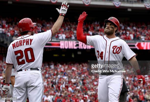 Bryce Harper of the Washington Nationals high fives teammate Daniel Murphy after Harper hit a home run in the sixth inning of the Opening Day game...