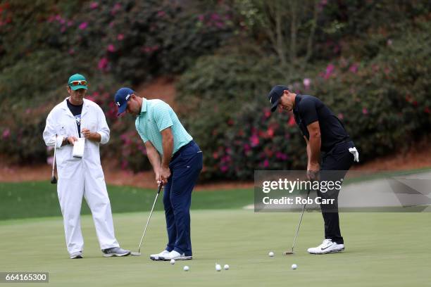 Gary Woodland of the United States and Brooks Koepka of the United States putt on the 13th hole during a practice round prior to the start of the...