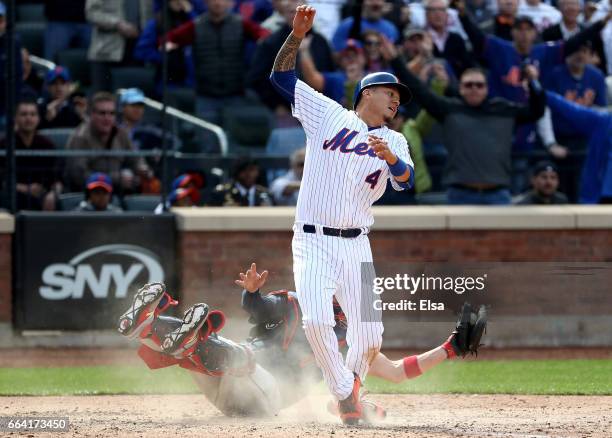 Tyler Flowers of the Atlanta Braves tires to make the tag as Wilmer Flores of the New York Mets slides home safely in the seventh inning during...