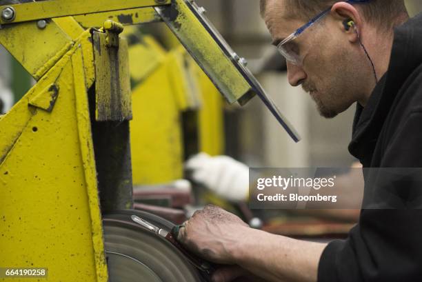 An employee polishes the metal on a pocket knife at the W.R. Case & Sons Cutlery Co. Manufacturing facility in Bradford, Pennsylvania, U.S., on...