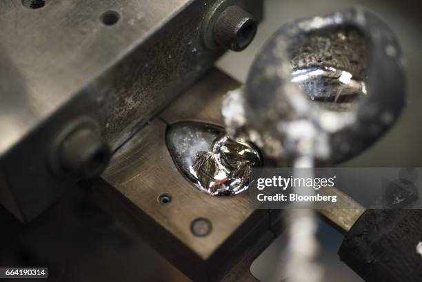 An employee pours molten metal into a pommel mold at the W.R. Case & Sons Cutlery Co. Manufacturing facility in Bradford, Pennsylvania, U.S., on...